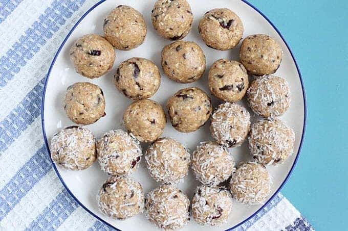 no-bake chocolate peanut butter balls on white plate on striped tea towel