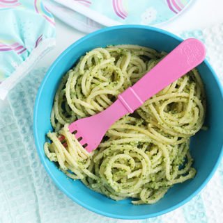 broccoli pesto on spaghetti in blue bowl with pink fork