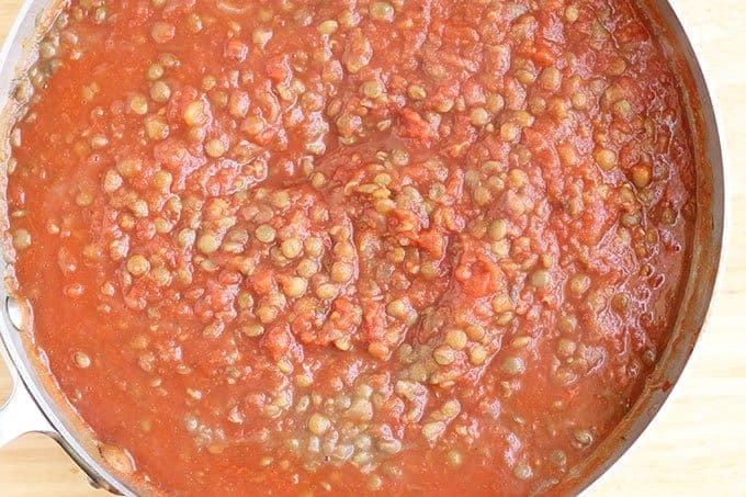 cooked lentils and tomatoes in saucepan