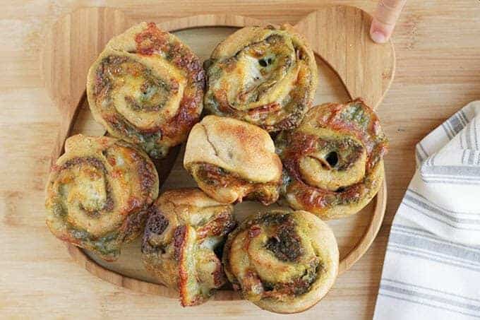 pesto pizza rolls on wooden plate and cutting board