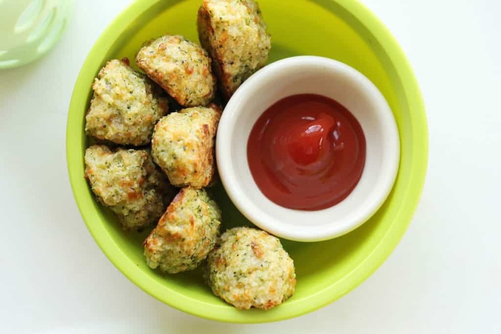 homemade broccoli tots in green bowl with ketchup