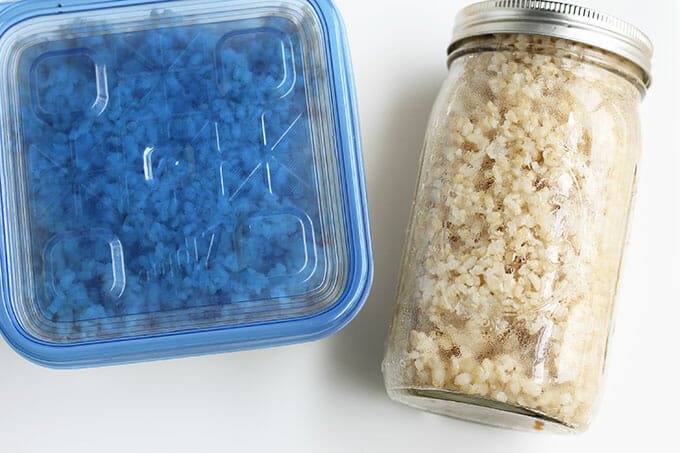 cooked brown rice in storage containers and jars