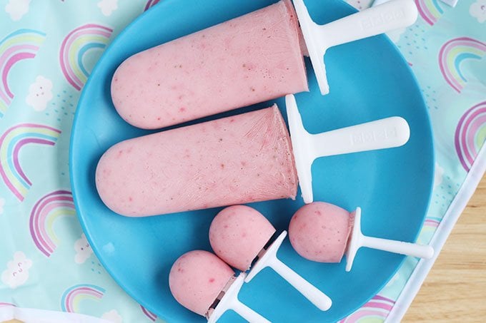strawberry frozen yogurt pops in molds on blue plate