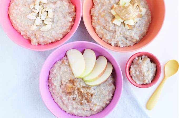 steel cut oatmeal recipe with apples in three pink and purple bowls with baby bowl