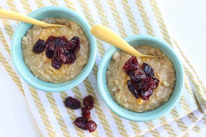 baby oatmeal with butternut squash and cranberries in blue bowls with yellow spoons