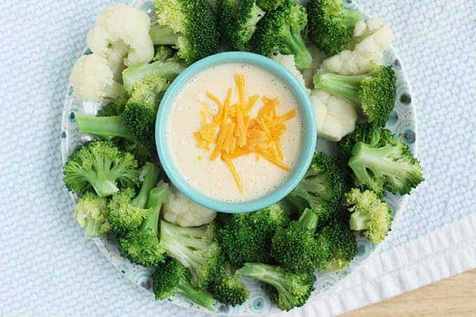 cauliflower cheese sauce in bowl with broccoli and cauliflower