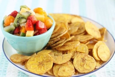fruit salsa in blue bowl with plantain chips on plate