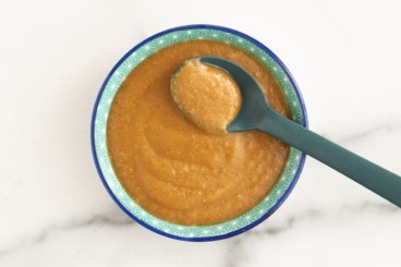 Peanut sauce in blue bowl with spoon.