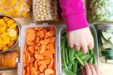 meal prepped veggies with kids hands