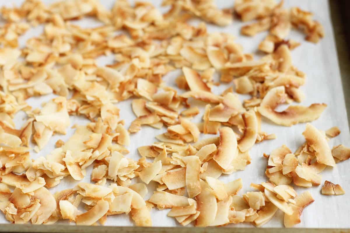golden brown baked coconut chips on parchment paper.