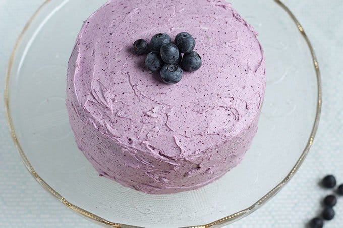frosted blueberry smash cake with blueberries on top