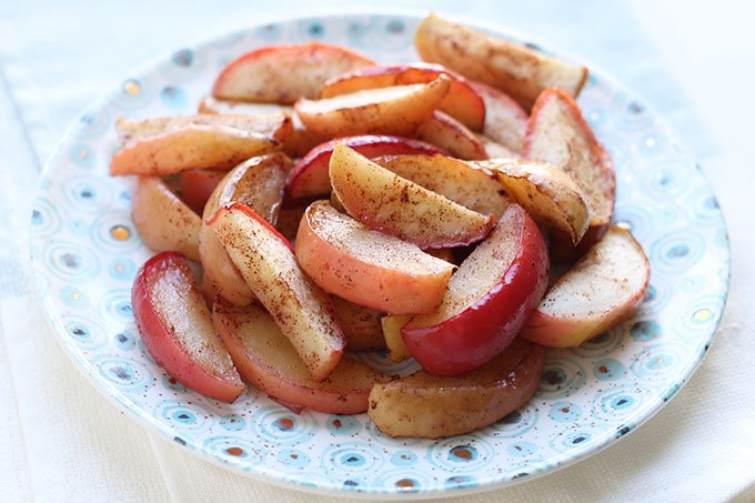 slices of baked apples on plate with cinnamon
