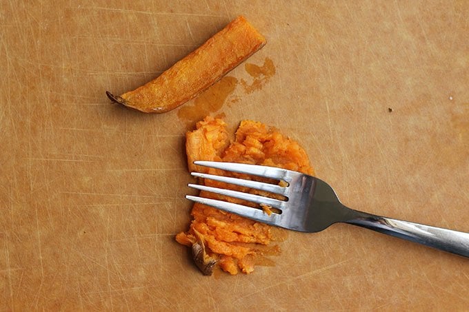 mashing sweet potato with a fork