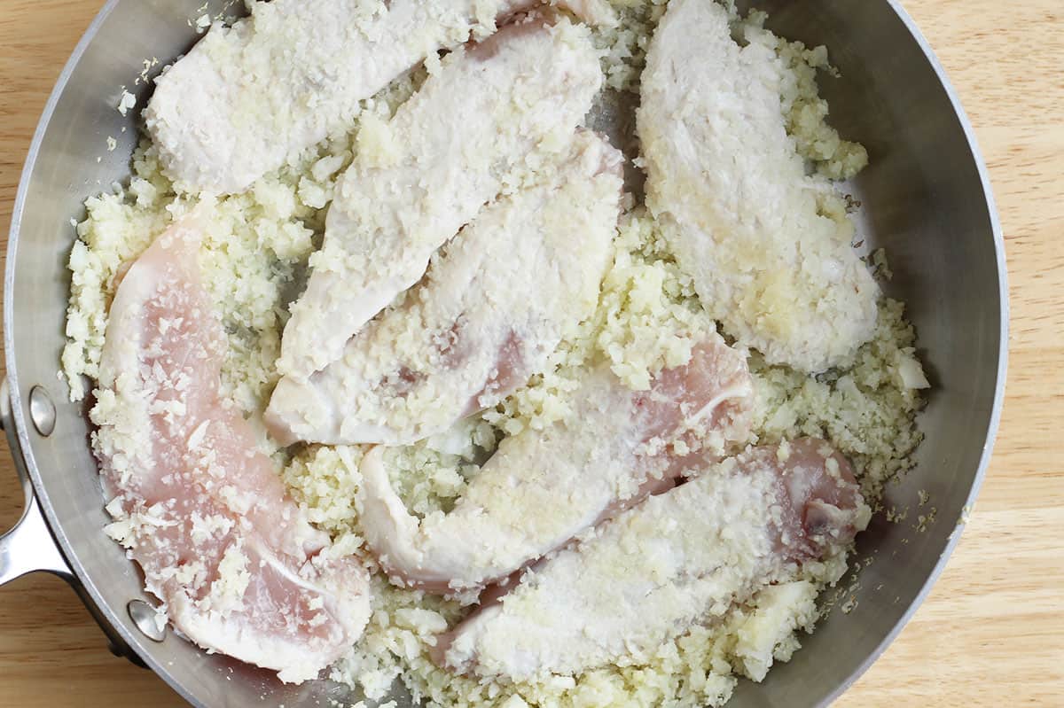 cauliflower rice and chicken cooked in pot.
