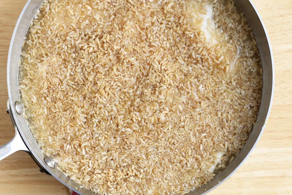 cooking rice in pan with chicken.