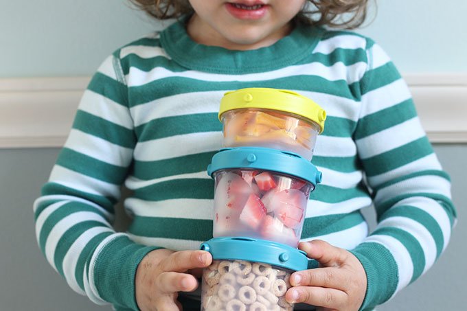 toddler holding snack cups