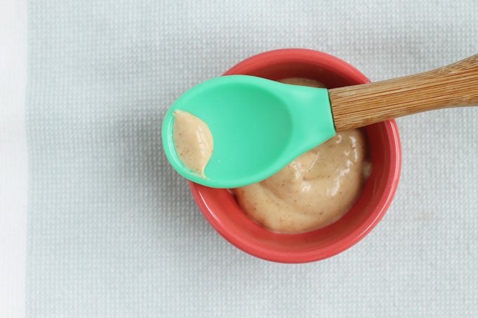 peanut butter puree in small bowl with baby spoon