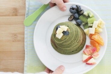 spinach banana pancakes on plate with fruit