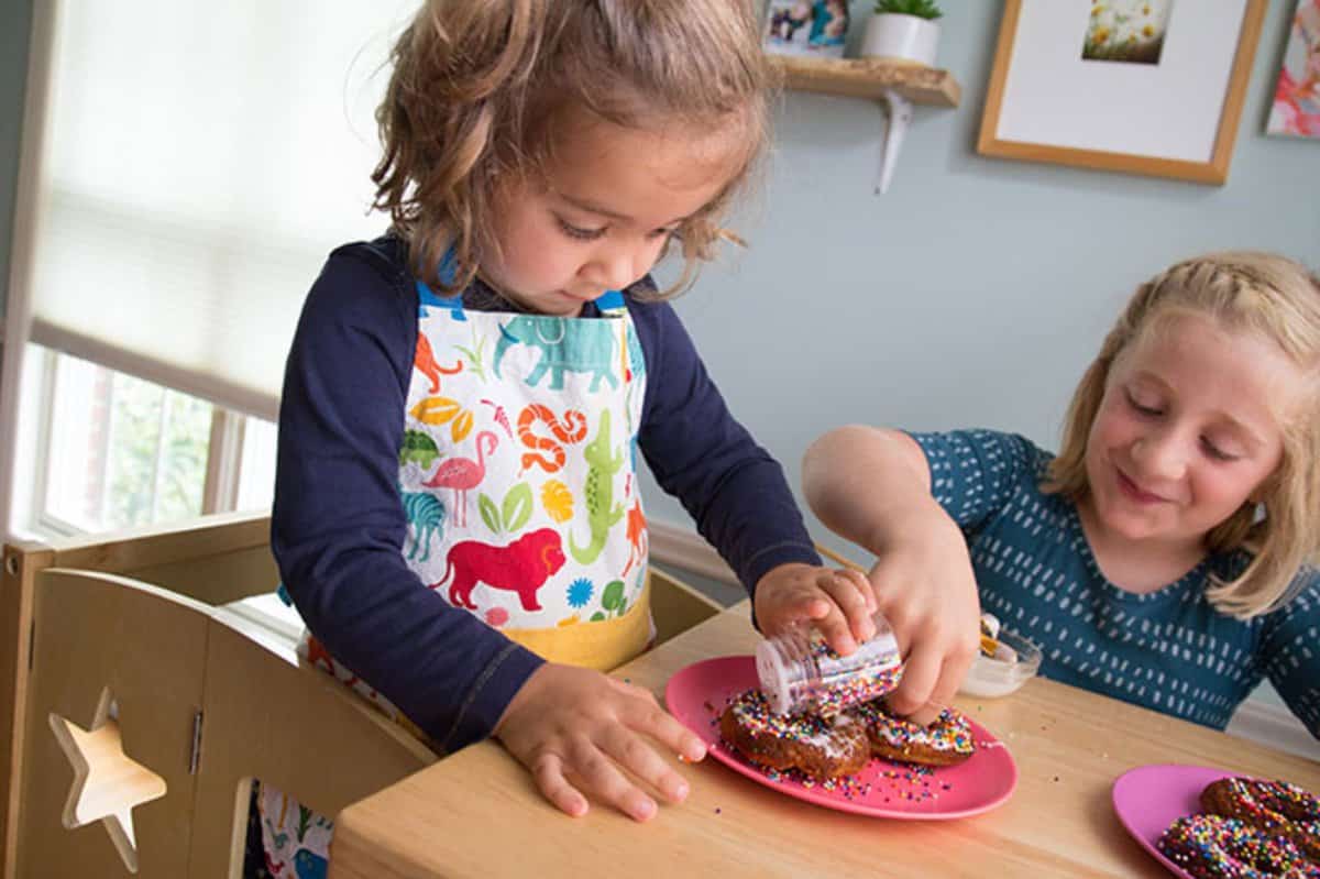 girls-putting-sprinkles-on-donuts