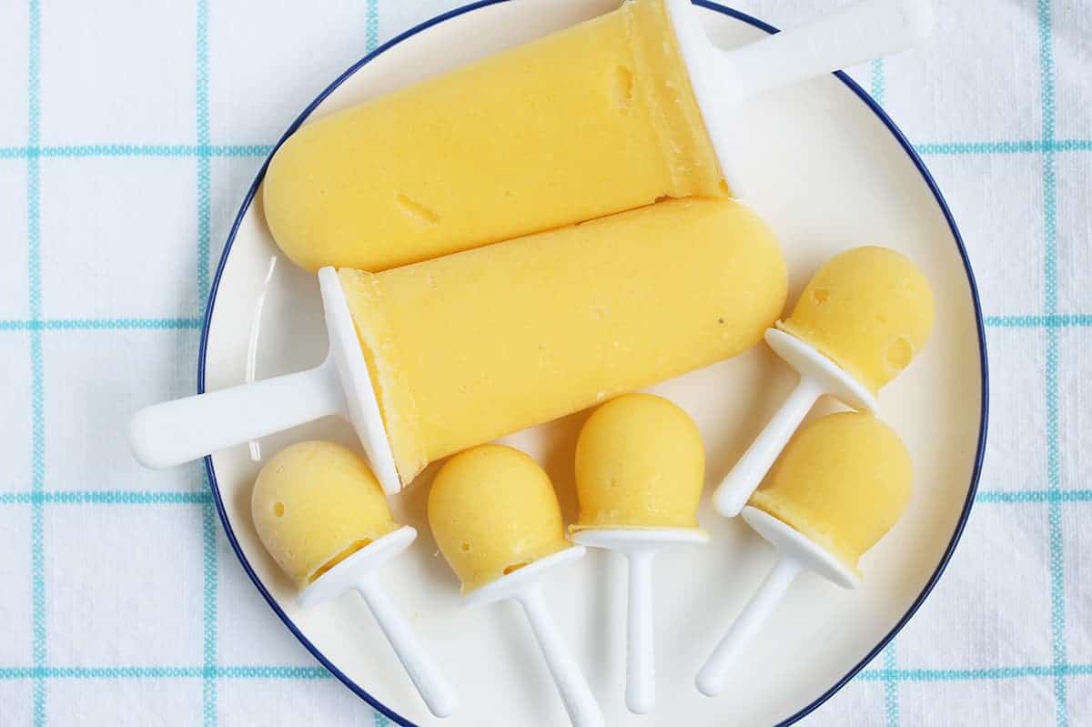 mango popsicles on white plate