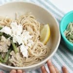 spaghetti with sausage and feta in white bowl