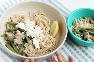 spaghetti with sausage and feta in white bowl