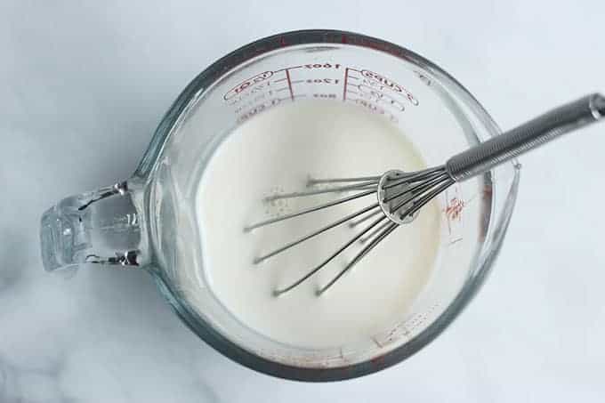 vanilla milk in measuring cup with whisk