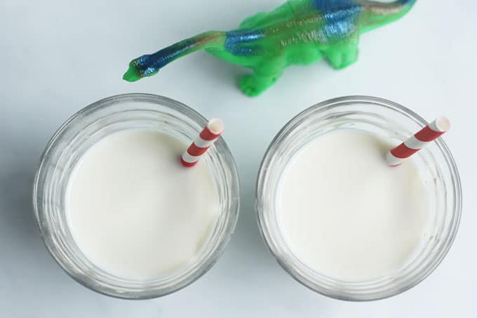 cups of vanilla milk with dinosaur