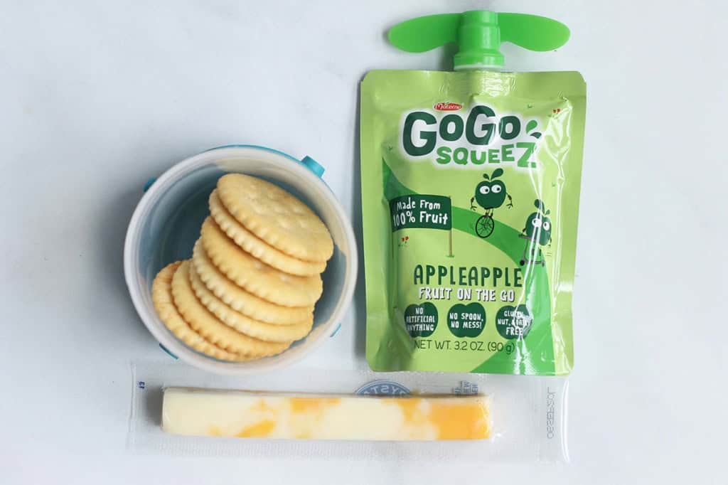 cheese and crackers with applesauce pouch on counter.