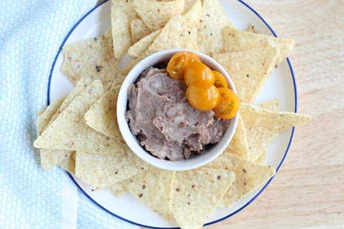 refried bean dip with chips on white plate