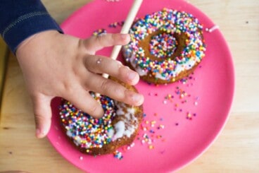 donuts-and-toddler-hands-with-pink-plate