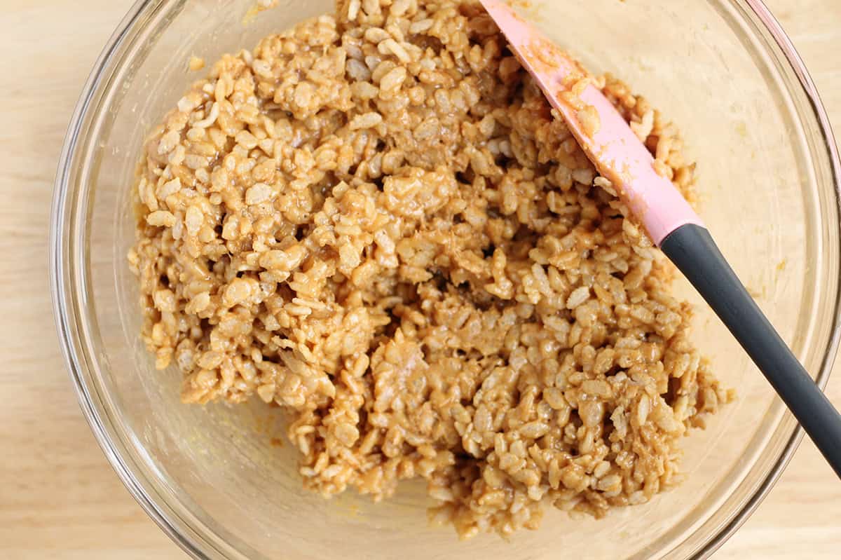 Peanut butter crispy rice mixture stirred in a bowl.