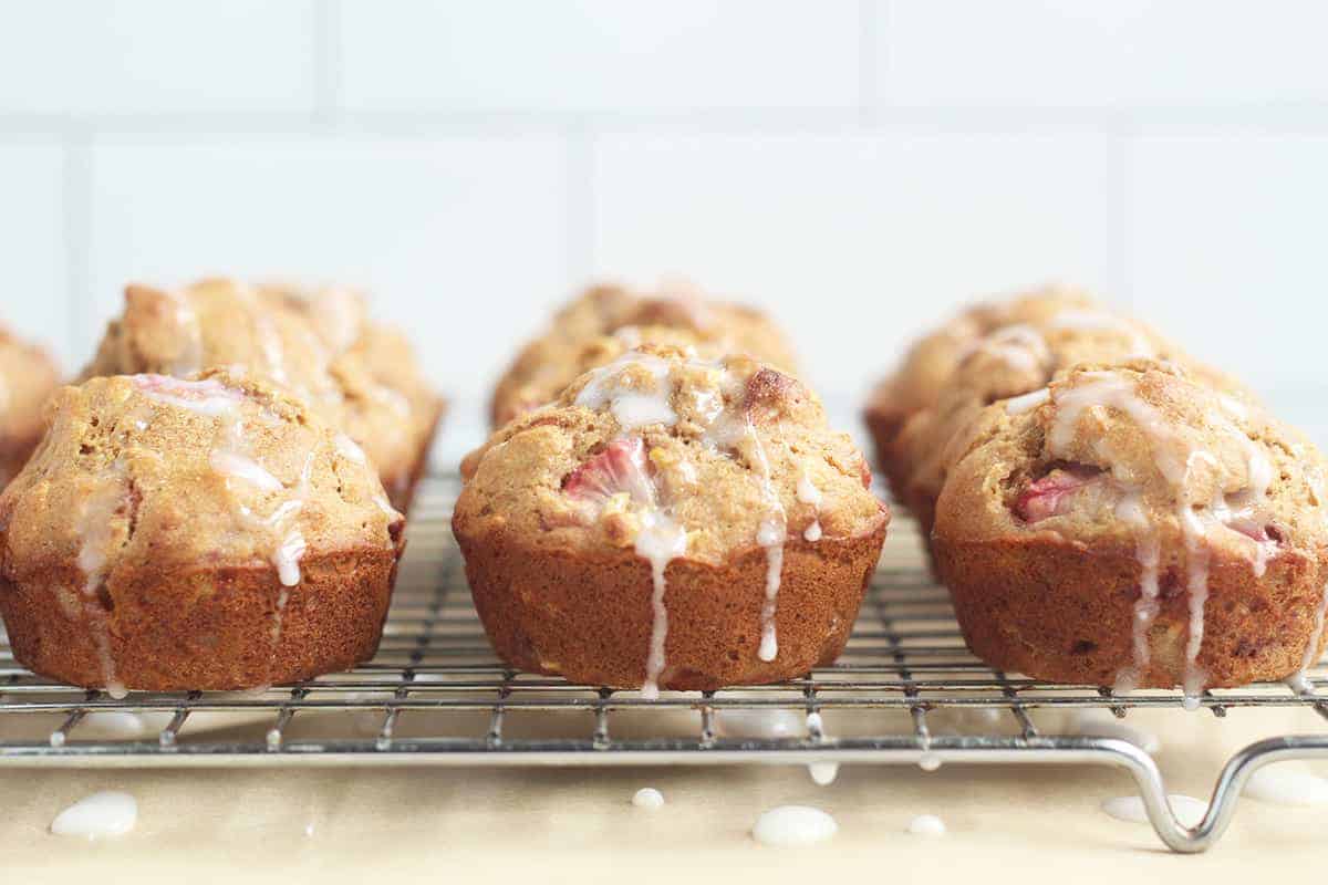 strawberry muffins with icing on wire rack