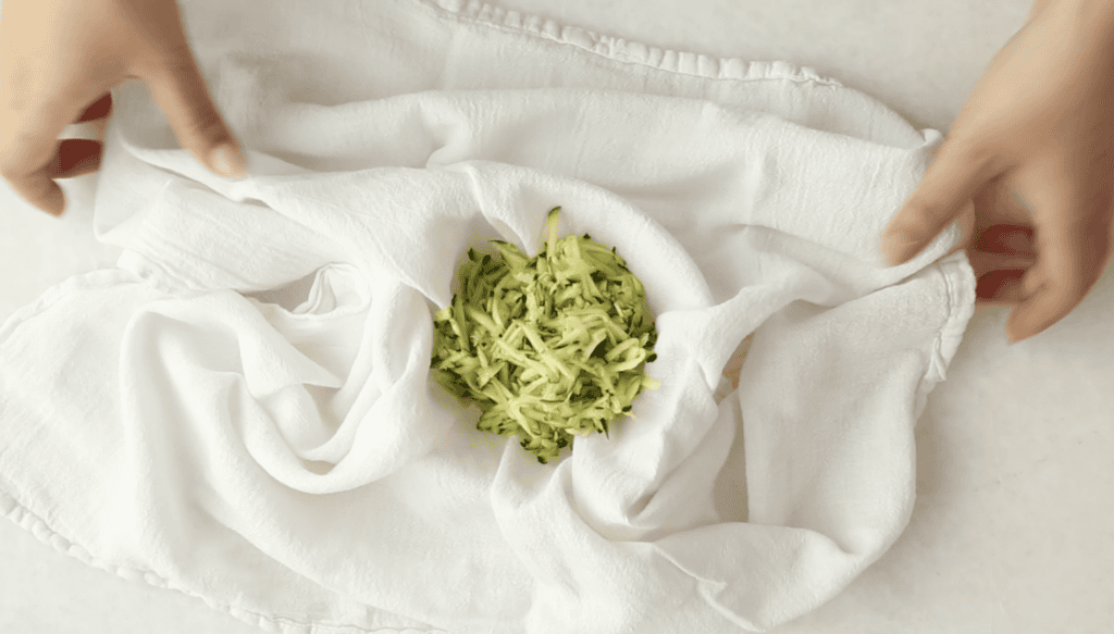 Squeezing shredded zucchini out for zucchini carrot muffins.