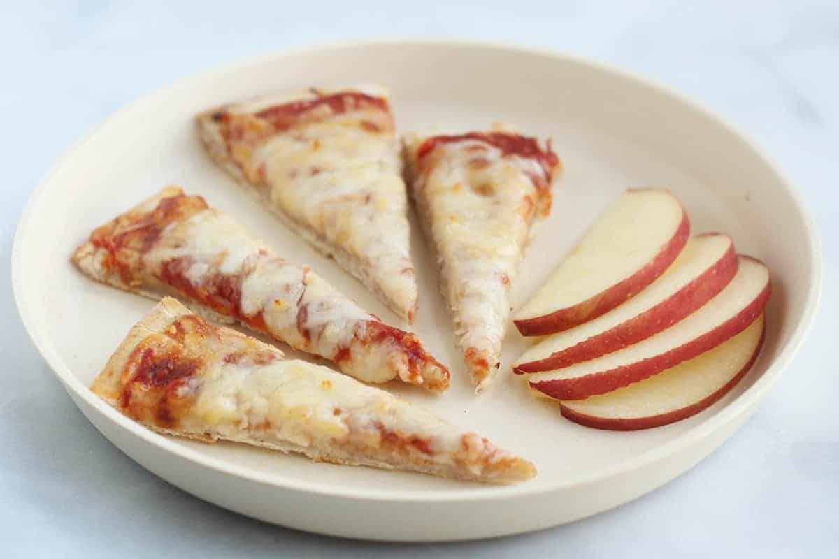 flatbread pizza slices on plate with apple slices