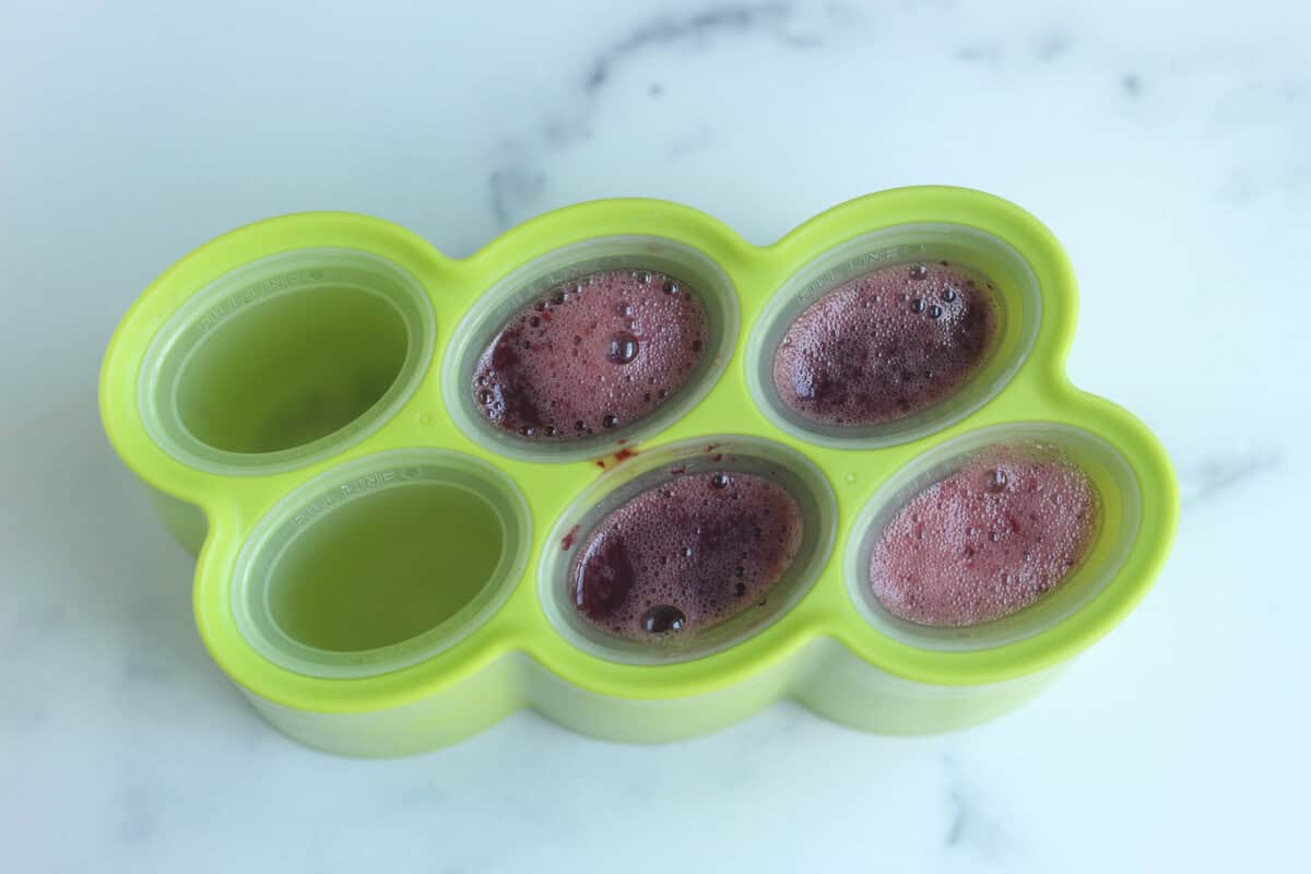 Filling popsicle mold for grape pops.