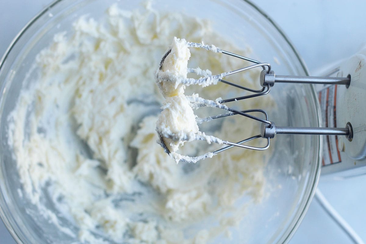 beating butter and sugar in a bowl with a mixer.