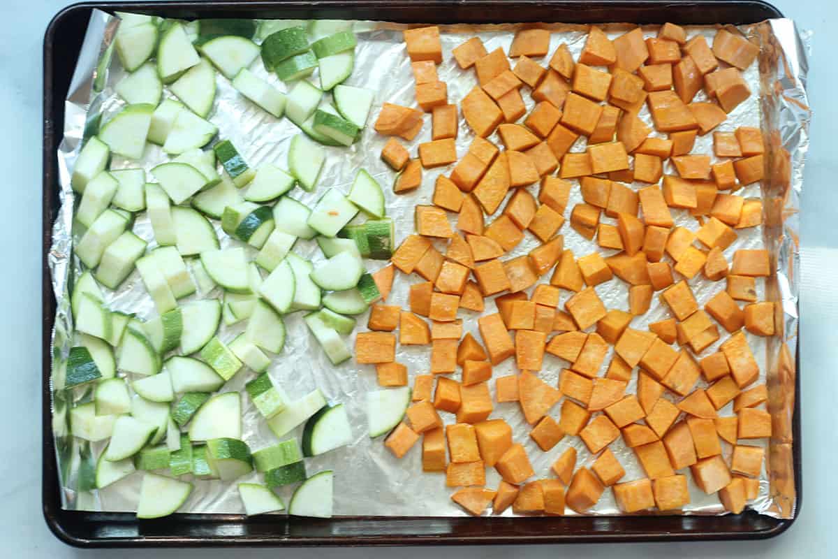 diced zucchini and sweet potato on sheet pans.