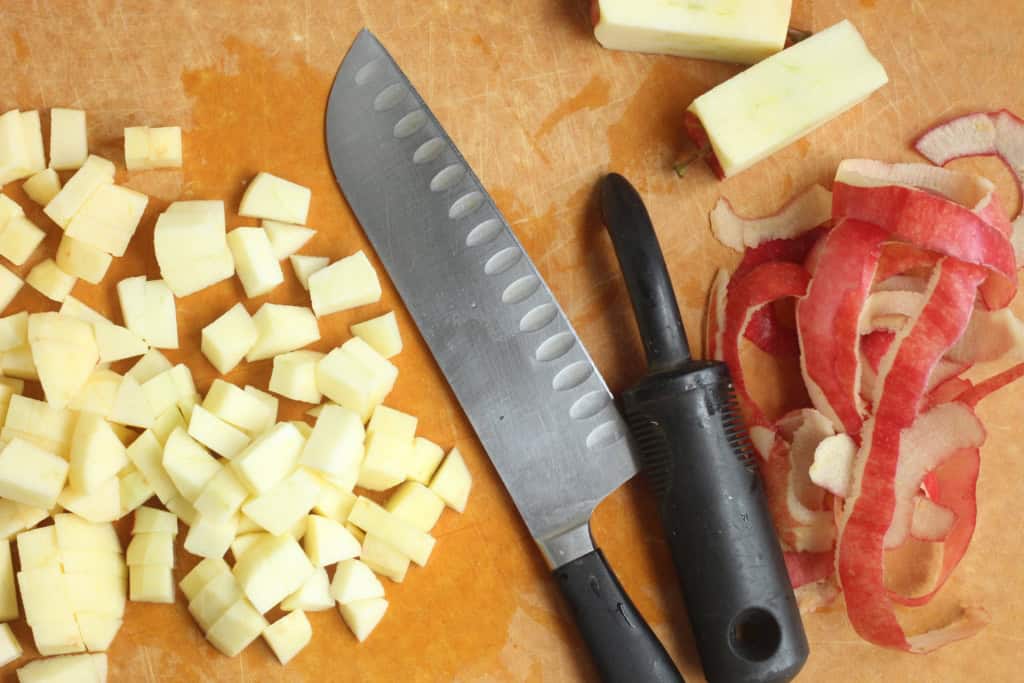 Chopping apples on cutting board for apple puree.