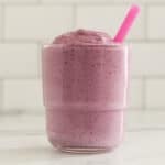 blueberry pregnancy smoothie in glass with pink straw.