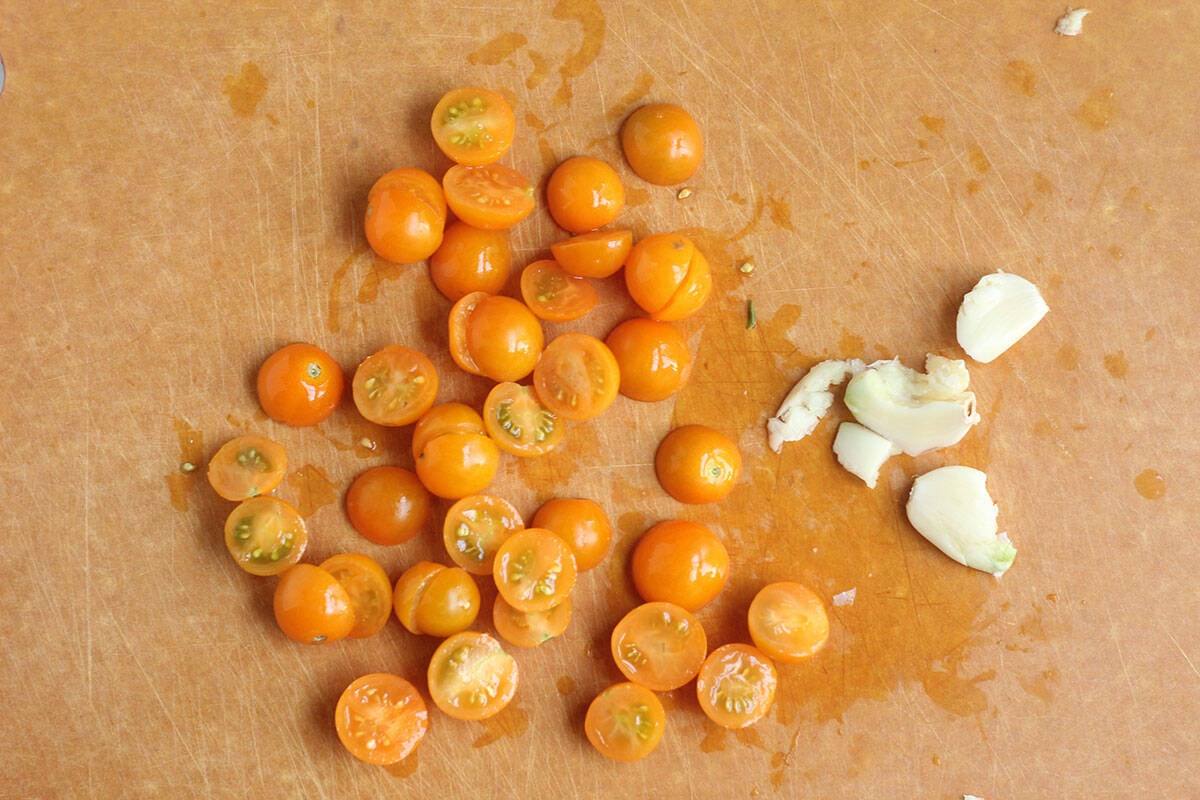 sliced tomatoes and garlic on cutting board.