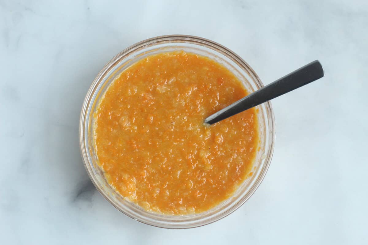 Wet ingredients for squash muffins in glass bowl.
