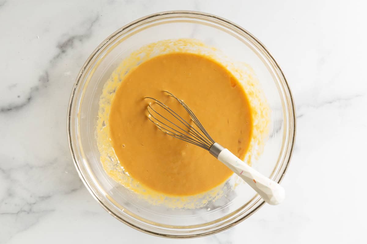Wet ingredients in glass bowl for sweet potato waffles.