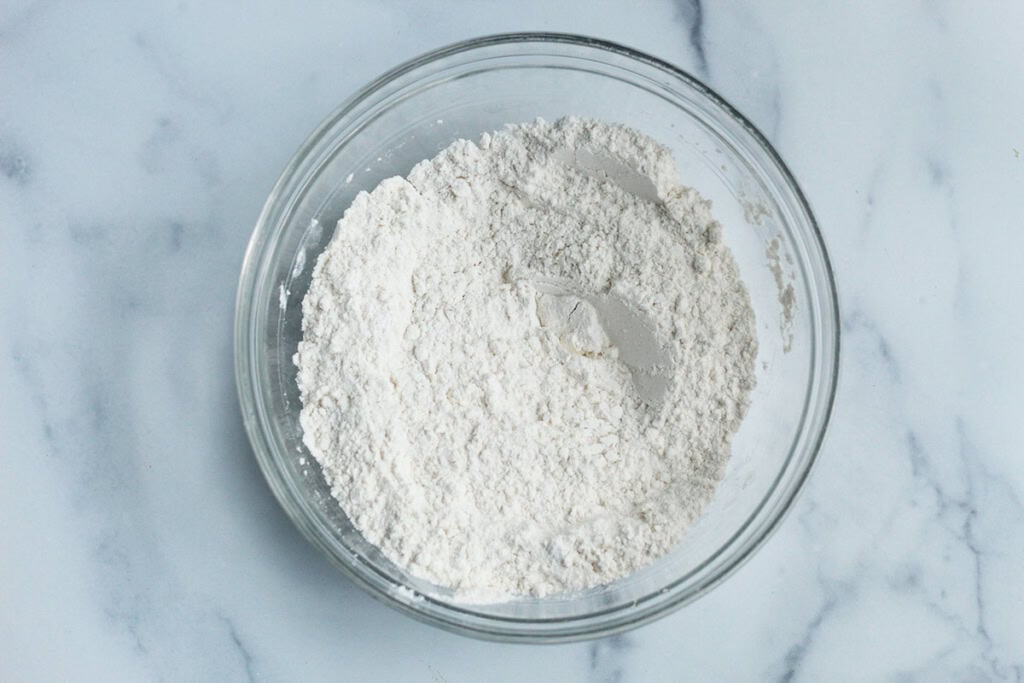 Dry ingredients for birthday cake muffins in glass bowl.