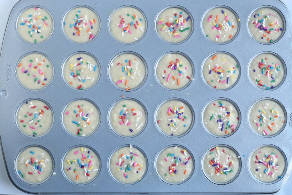 Birthday cake muffins in muffin pan before baking.