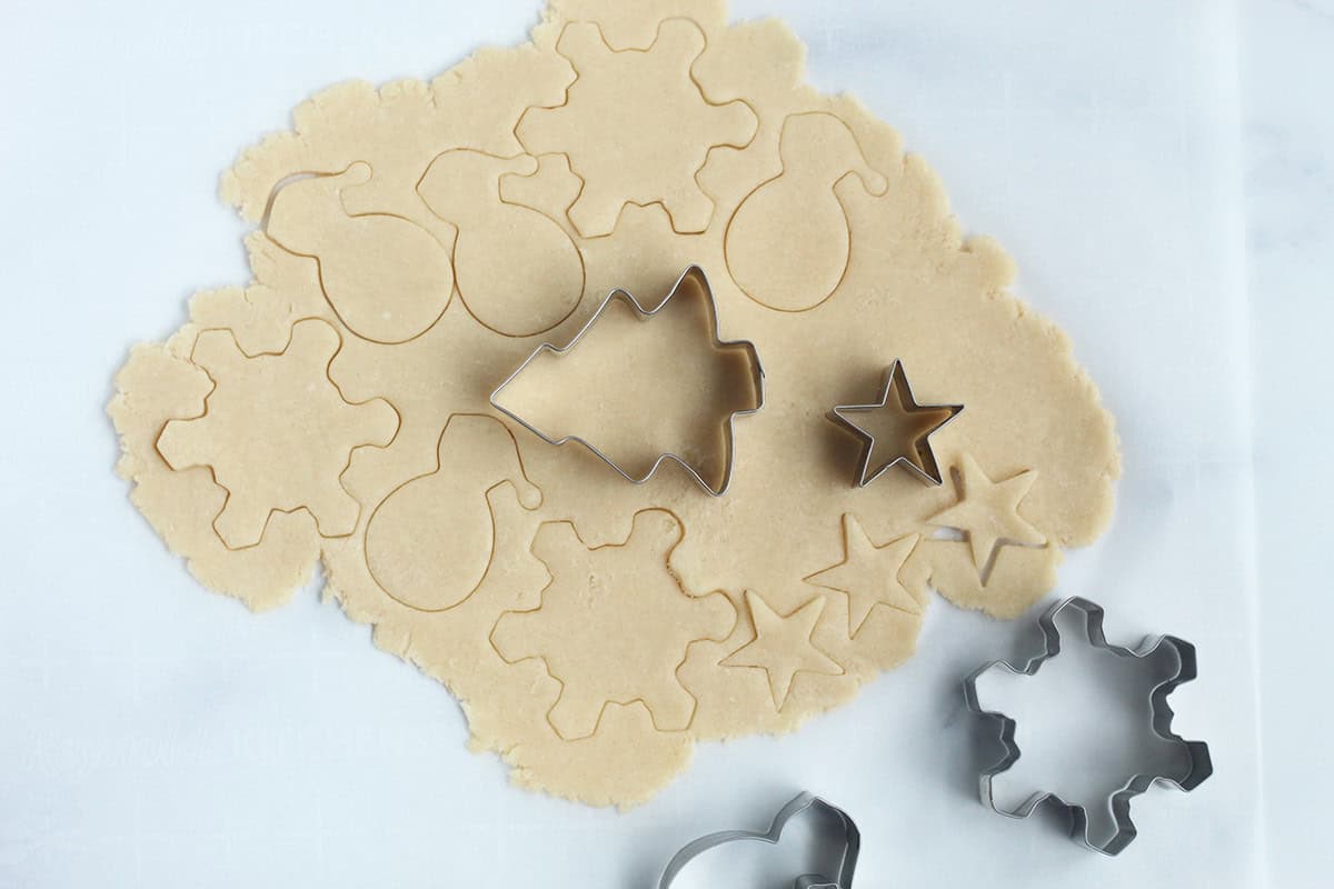 Cutting out christmas cookies with cookie cutter.