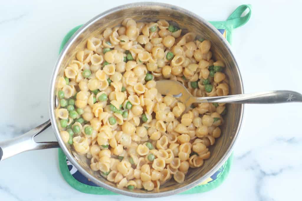 Mac and cheese with peas in a pot.