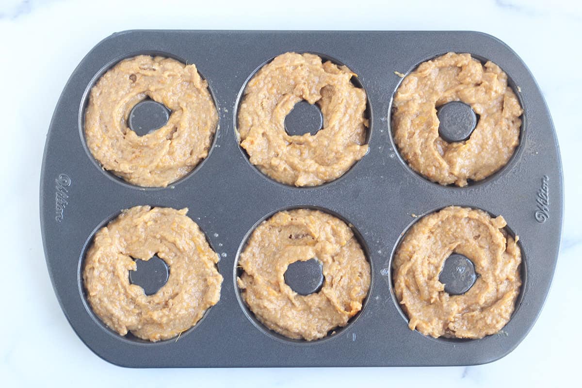 Sweet potato donuts in donut pan before baking.