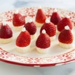 Strawberry santas on red and white christmas plate.