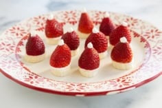 Strawberry santas on red and white christmas plate.